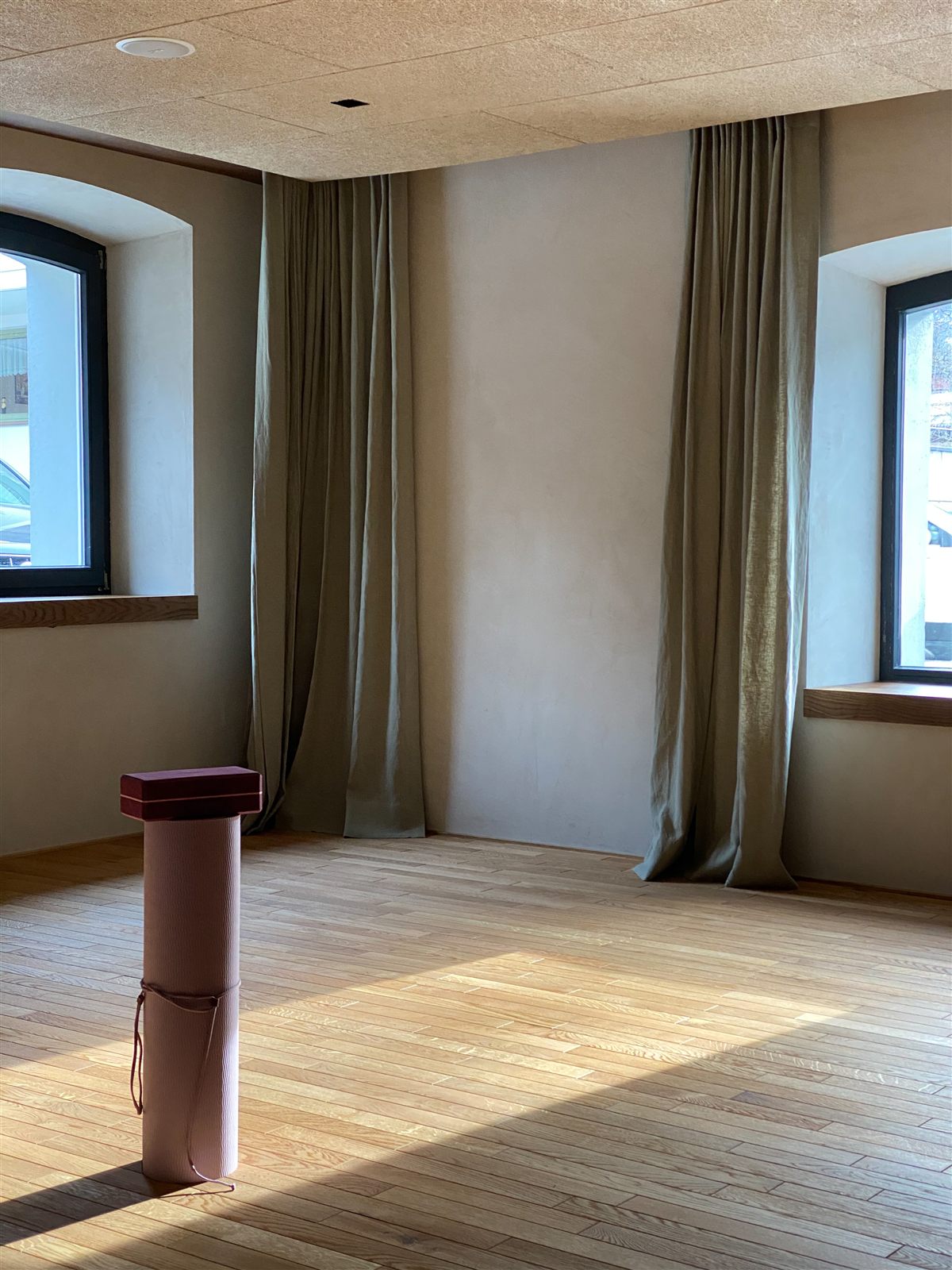 Studio B mit Yogamatte und Sonnenlicht auf dem Holzboden